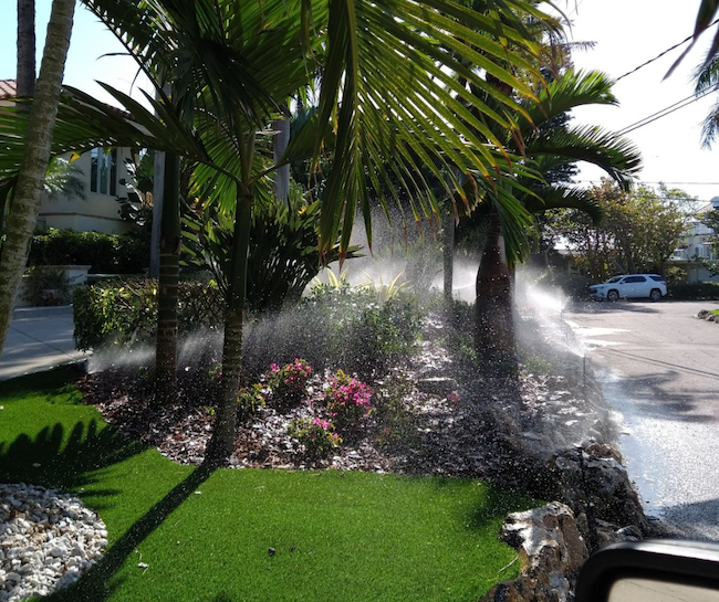 irrigation system watering lawn and flower beds