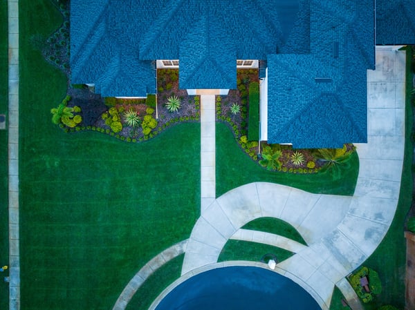 aerial view of house with green grass and landscape beds