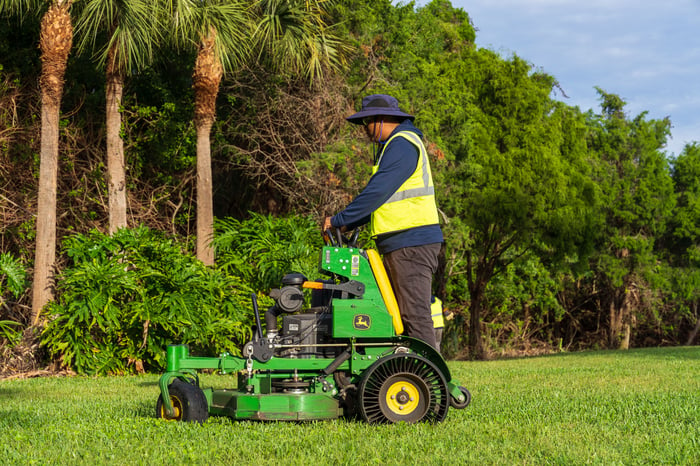 landscape crew mowing large green grass area