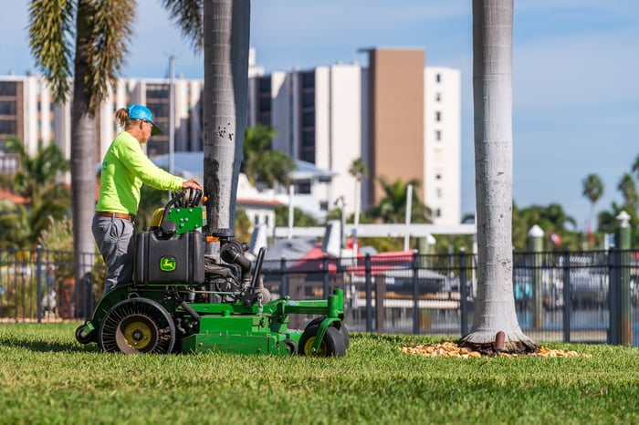 residential landscape maintenance crew mowing grass