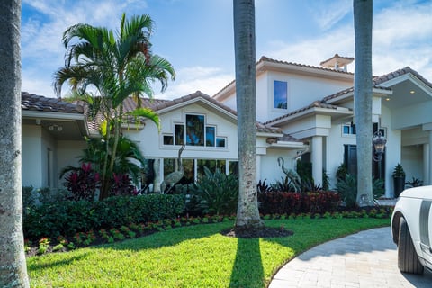 front of residential property with grass and palms