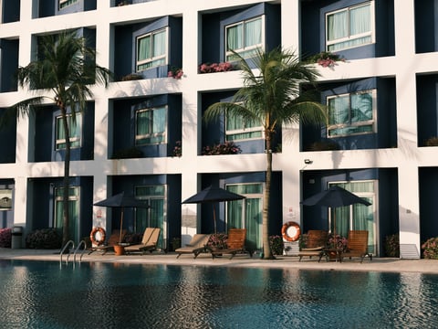 hotel building with pool and palm trees